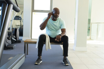 African american senior man wearing wireless earphones at the gym