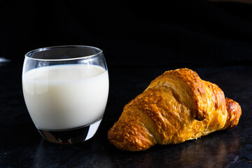 Fresh white bread and milk in white glass on black stone table background. Top view and Studio shot