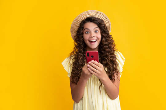 Happy Teenager Girl 12, 13, 14 Years Old With Smart Phone. Hipster Teen Girl Types Message On Cellphone, Enjoys Mobile App. Kid Hold Smartphone Texting In Online Social Media. Internet Addiction.