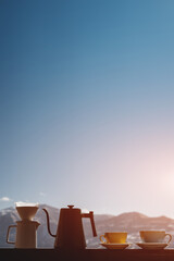 tasty filter coffee kettle with paper, drip, two cups, on nature background