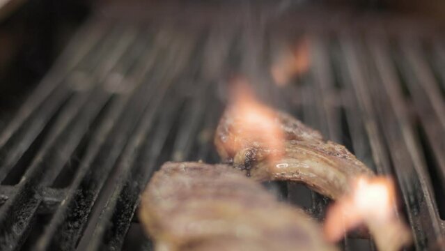 Rack of lamb being grilled in restaurant kitchen, cook, chef, grilling meat. 4K 24FPS