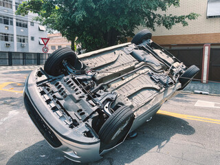 Car turned upside down after accident on city street.