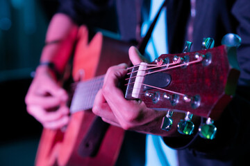 Hombre tocando la guitarra acústica con cuerdas de metal y tono de madera  clásica