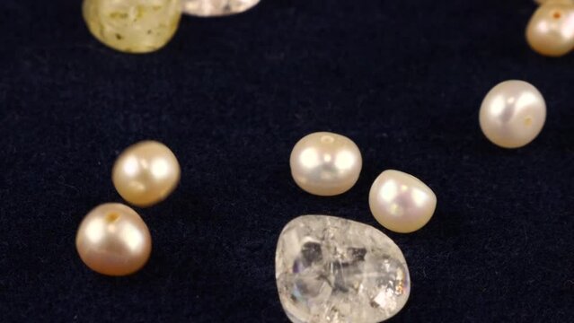 Natural pearls, quartz, rock crystal fall on dark blue