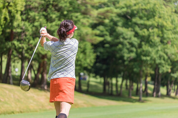 ゴルフ場でゴルフをするゴルファーの女性(後ろ姿・ティーショット・ゴルフコンペ)　撮影協力：あづみ野カントリークラブ