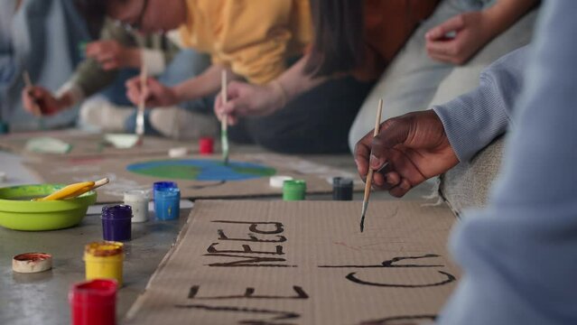 A group of young people draw posters and protest against environmental pollution