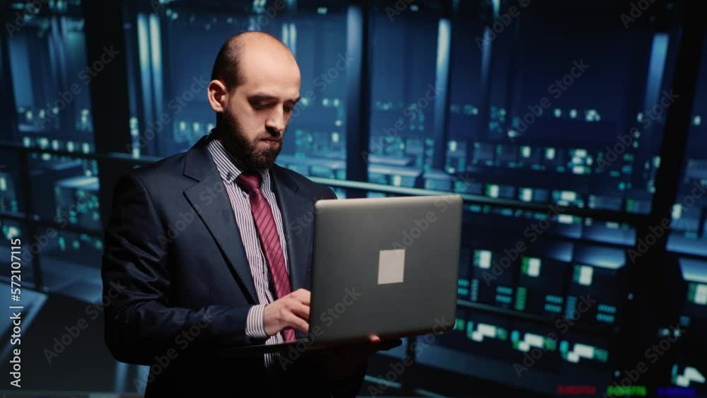 Poster it manager technical support operator holding laptop in data center, working on computer mainframe w