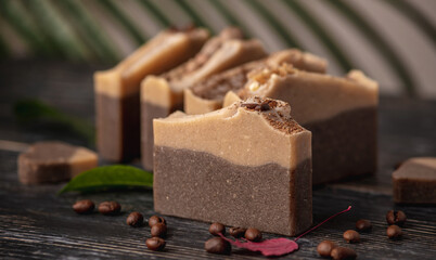 Pieces of fragrant coffee and chocolate soap on the black wooden table. Concept of natural eco soap and cosmetics