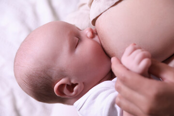 Mother breastfeeding her newborn baby, closeup view