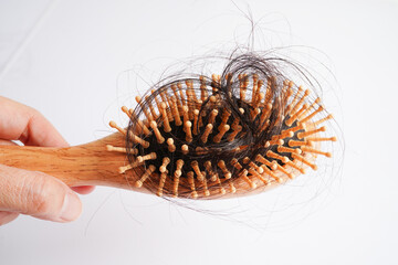 Asian woman have problem with long hair loss attach to comb brush.