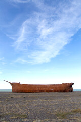 Rusty hull of the old British ship Marjory Glenn burned down in 1911. It lies today on the shores...
