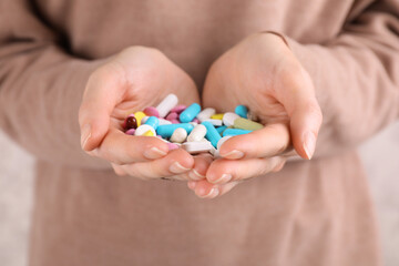Woman holding pile of antidepressants, closeup view