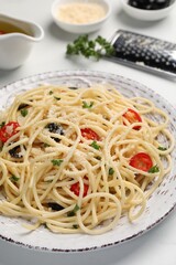 Delicious pasta with olives, tomatoes and parmesan cheese on white table, closeup