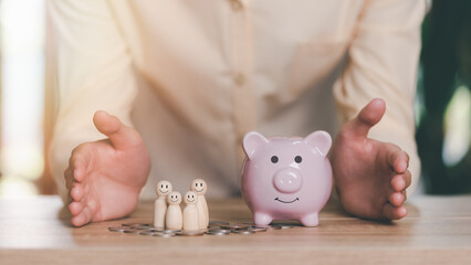 Men show protection and safety protection to wooden dolls and piggy banks , The concept of insurance management planning, for both health and financial safety Reduce risks to property and family