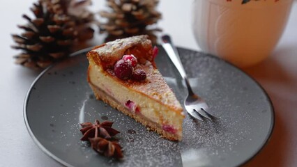 Slowly focusing image of a piece of cake placed on grey plane next to metal fork. Two cones and a cup blurred in the background. High quality 4k footage