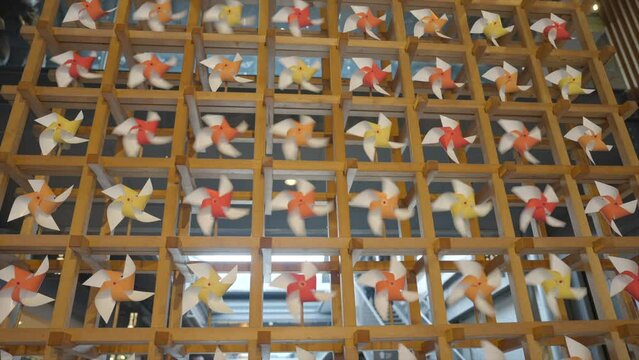 This video shows a creative wall of origami paper pinwheels spinning in the wind.