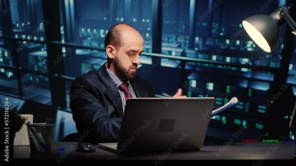 Poster male infrastructure engineer working in render farm running diagnostics on mainframe computer system