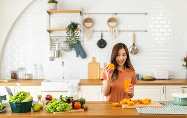 Portrait of beauty body slim healthy asian woman drinking glass of juice and orange.young girl preparing cooking healthy drink with fresh orange juice in kitchen at home.Diet concept.healthy drink