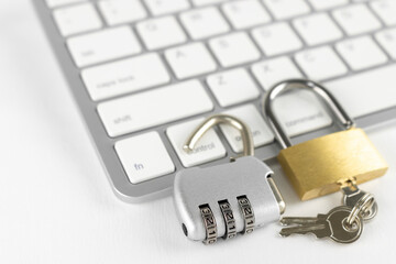キーボードと、開錠された南京錠とダイヤルロック。2段階認証のイメージ