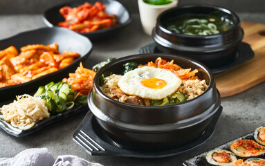 korean bibimbap bowl on table top with many different dishes - 572121368