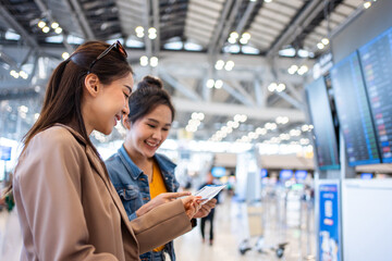Asian young women passenger checking depature boarding pass in airport