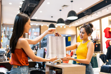 Asian young women purchasing clothes product in shopping mall center.