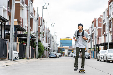 Asian young male ride surf skate board on street on the way to work.  © Kawee
