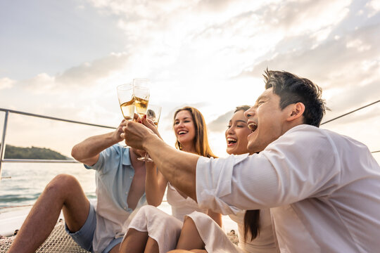 Group of diverse friends drink champagne while having a party in yacht