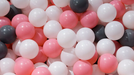 Colorful white black and pink plastic ball at the dry indoor pool ball kids playground.