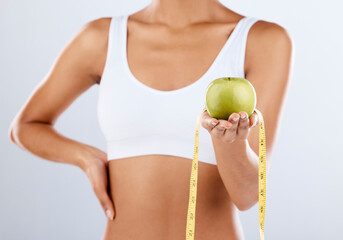 Diet, apple and tape measure with a fitness black woman in studio on a gray background for healthy...