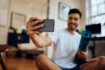 Close up of man taking selfie while exercising at home.