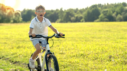 a boy learns to ride a bike on a sunny day