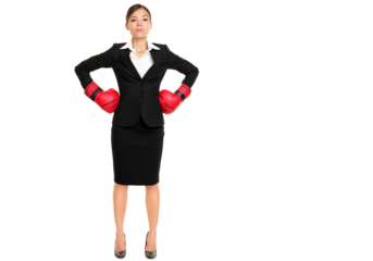 Strong business woman boss executive concept. Businesswoman standing intimidating wearing boxing gloves. Confident attitude by model in suit isolated cutout PNG on transparent background.