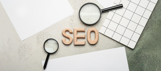 Abbreviation SEO with magnifiers, notebook and paper sheets on grunge background