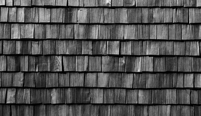 a house wall covered with small wooden tiles,black and white background for design
