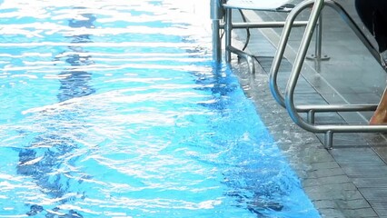 Slow motion medium shot of a disabled person getting out of the pool after his training