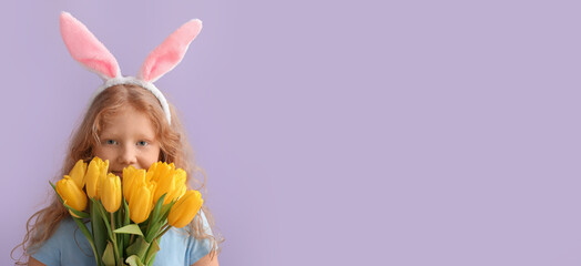 Funny little girl with Easter bunny ears and flowers on lilac background with space for text