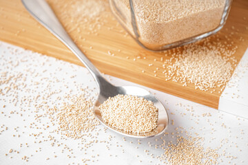 Spoon of amaranth seeds on light table, closeup