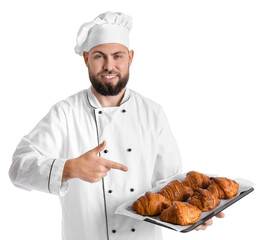 Male baker pointing at tray of tasty croissants on white background