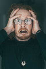 Terrified, red haired, glasses wearing man