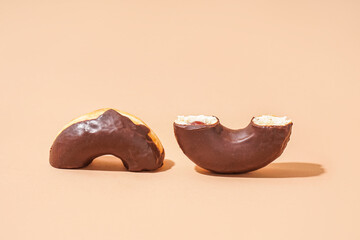 Halves of delicious chocolate donut on beige background
