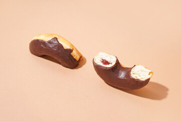 Halves of delicious chocolate donut on beige background