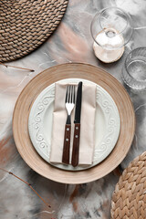 Beautiful table setting with plates and cutlery on grunge background