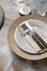 Beautiful table setting with plates and cutlery on grunge background, closeup