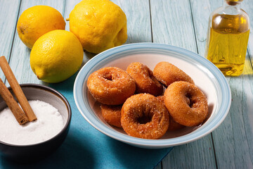 Close-up of homemade doughnuts fried with sugar and cinnamon on wooden background.