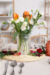 Obraz na płótnie Canvas Vase with flowers for International Women's Day celebration on dining table