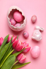 Fototapeta na wymiar Easter bunny, tulip flowers and painted eggs on pink background