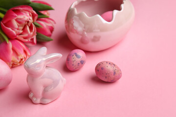 Easter bunny, tulip flowers and painted eggs on pink background