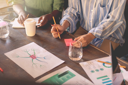 Businesswomen analyzing work documents with charts and graphs - Powered by Adobe