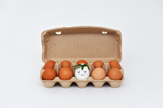 White egg with a smile in an eco-friendly paper tray box. Group of eggs.